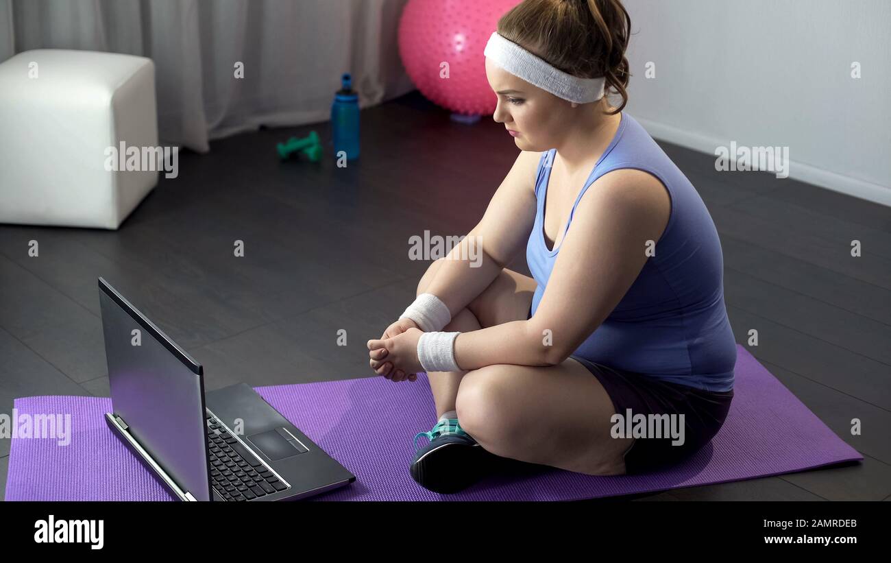 Donne obese guardare video online di metodi di formazione efficaci sul suo notebook Foto Stock