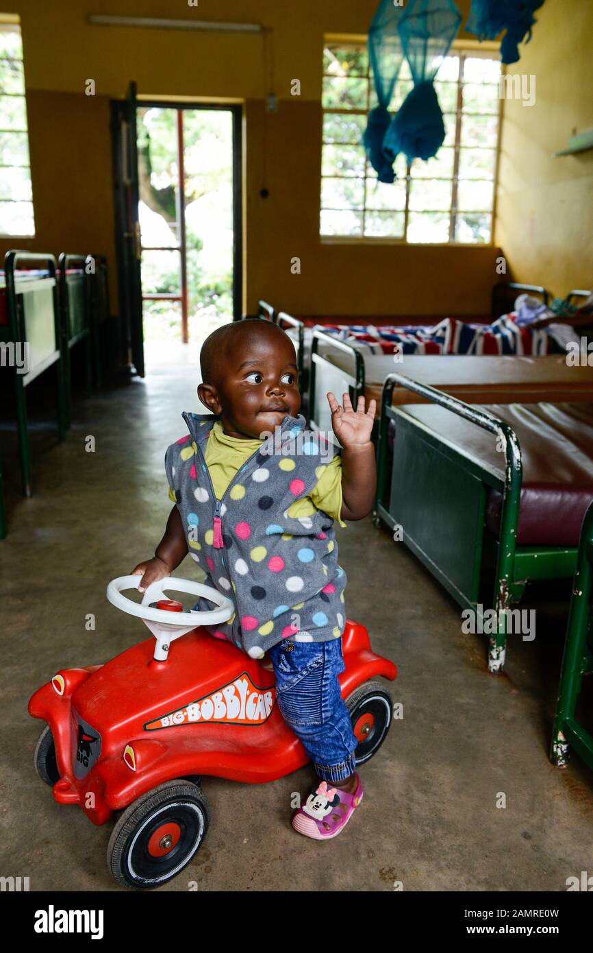 Rwanda, Butare, centro salute Gikonko, ragazzo con vettura giocattolo in plastica Bobby Car Foto Stock