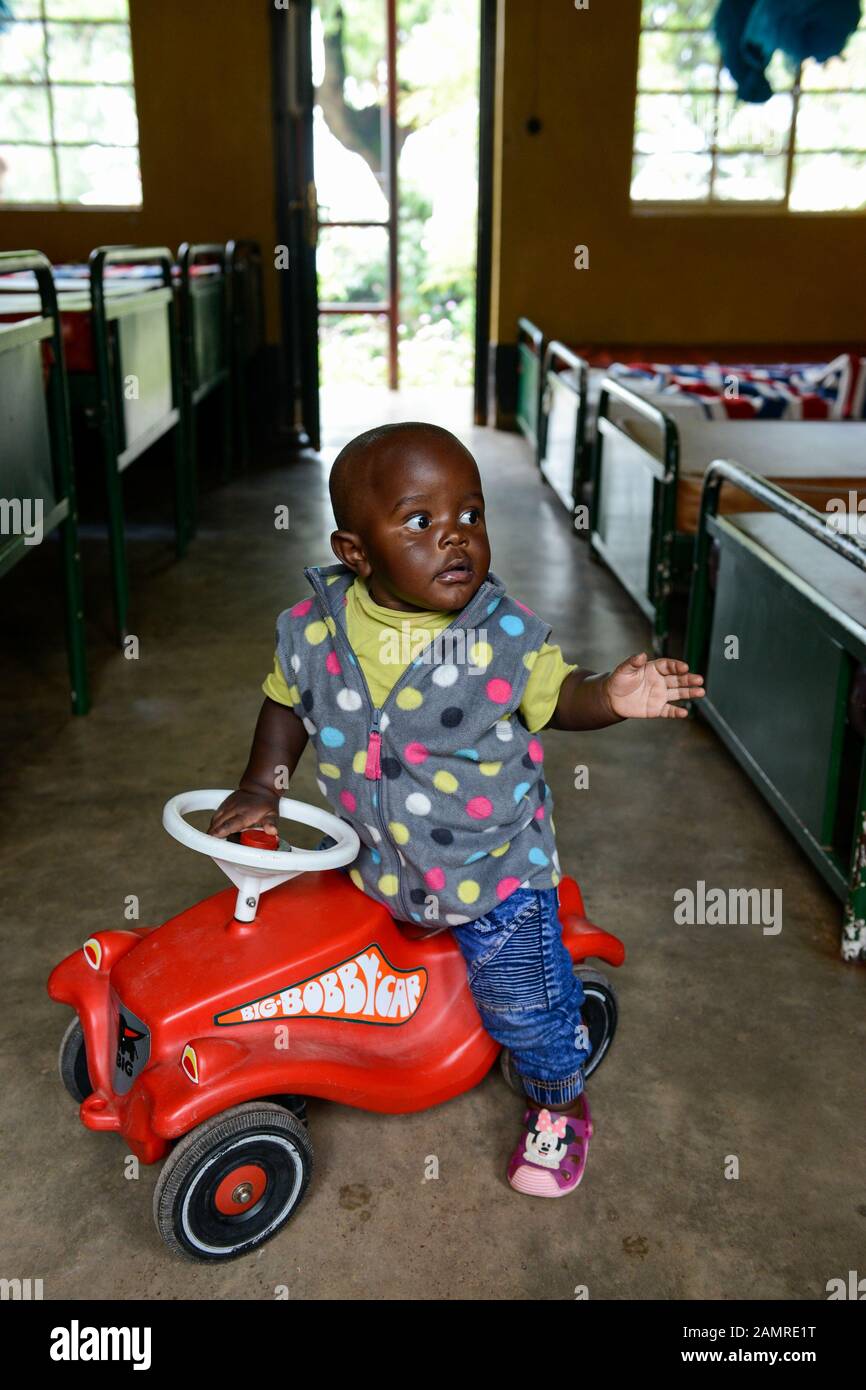 Rwanda, Butare, centro salute Gikonko, ragazzo con vettura giocattolo in plastica Bobby Car Foto Stock