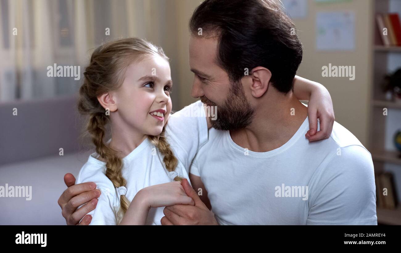 Padre parlando e abbracciando cute bambino, famiglia amore e cura, felice paternità Foto Stock
