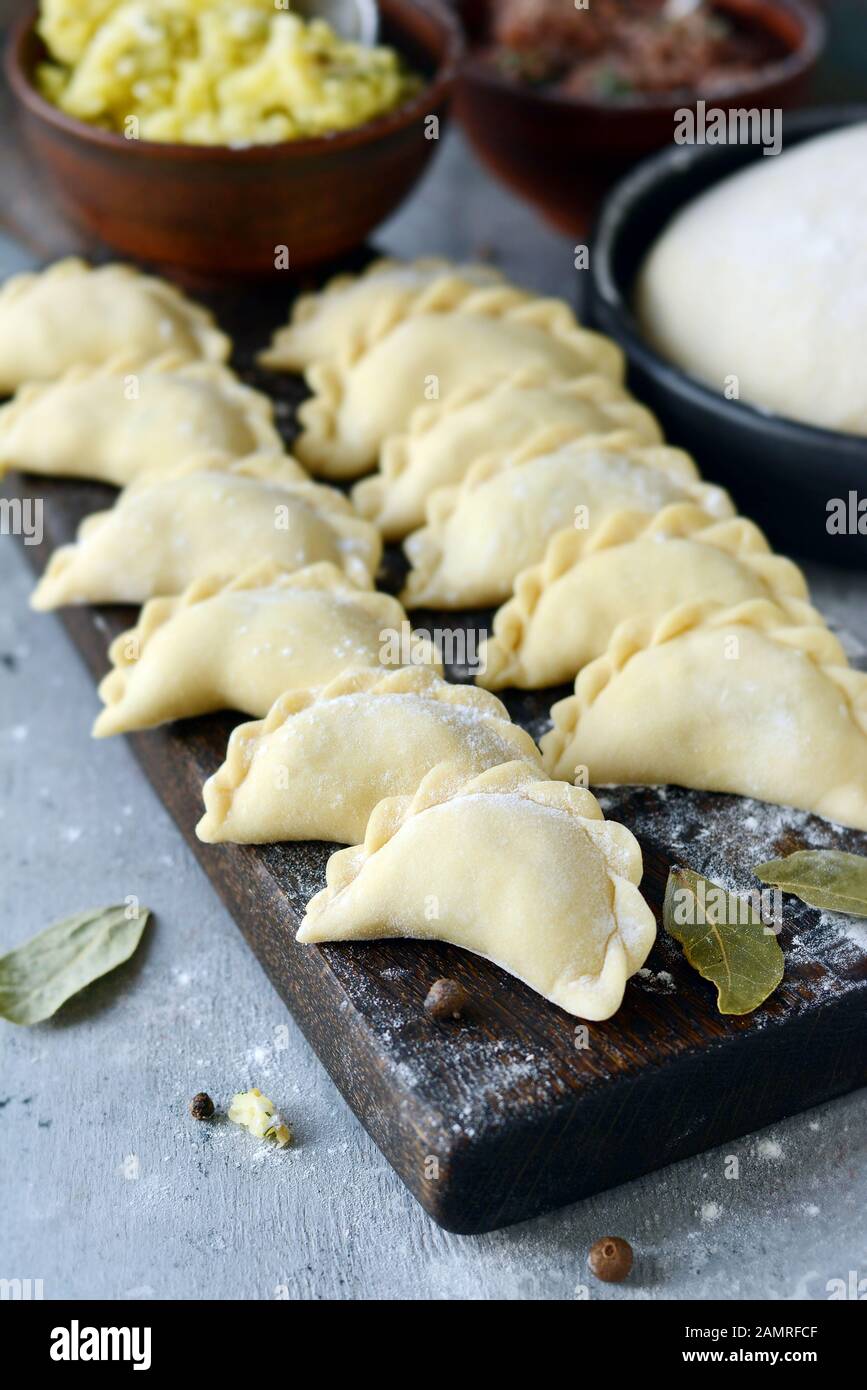 Gnocchi di patate con erbe su uno sfondo blu. Varenyky, vareniki, pierogi, pyrohy - gnocchi con riempimento. Foto Stock