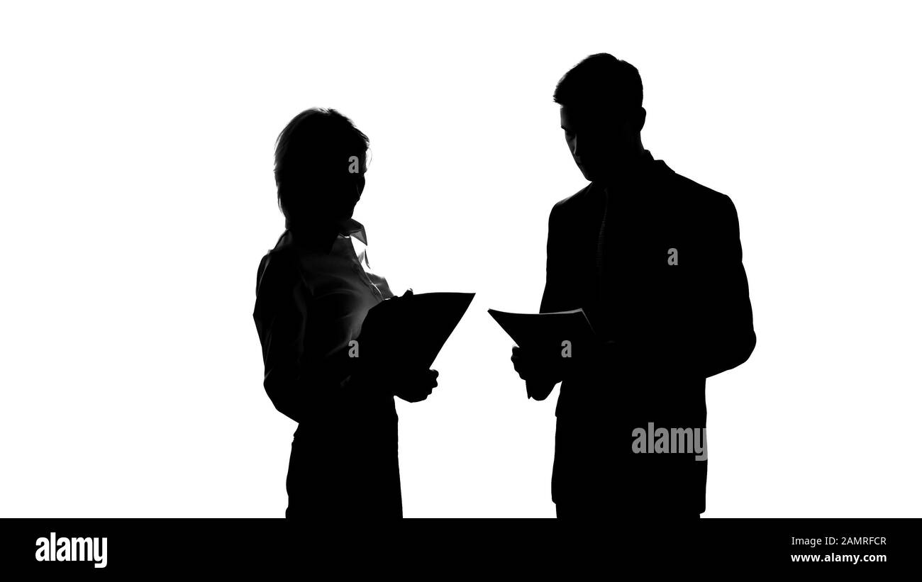 Silhouette femminile di boss che discute il progetto di business con il segretario maschile in ufficio Foto Stock