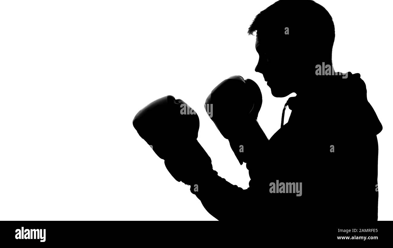 Silhouette maschile scura nel cappuccio attaccante avversario, ombra-boxe auto-difesa Foto Stock