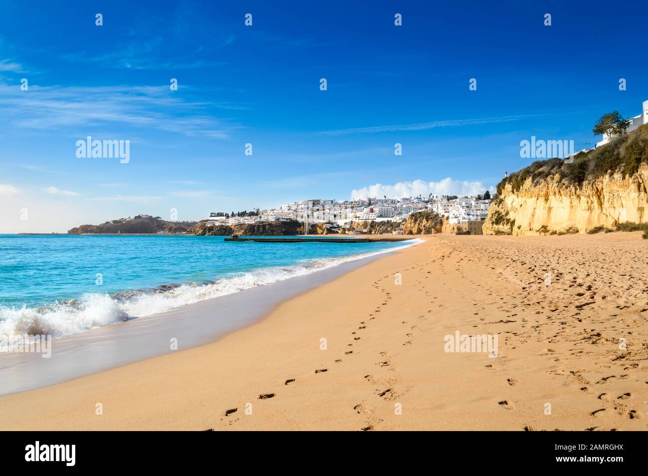 Albufeira villaggio resort, popolare destinazione turistica in Algarve, Portogallo. Onde che si infrangono contro l'ampia spiaggia sabbiosa Praia de Albufeira e vista su Foto Stock