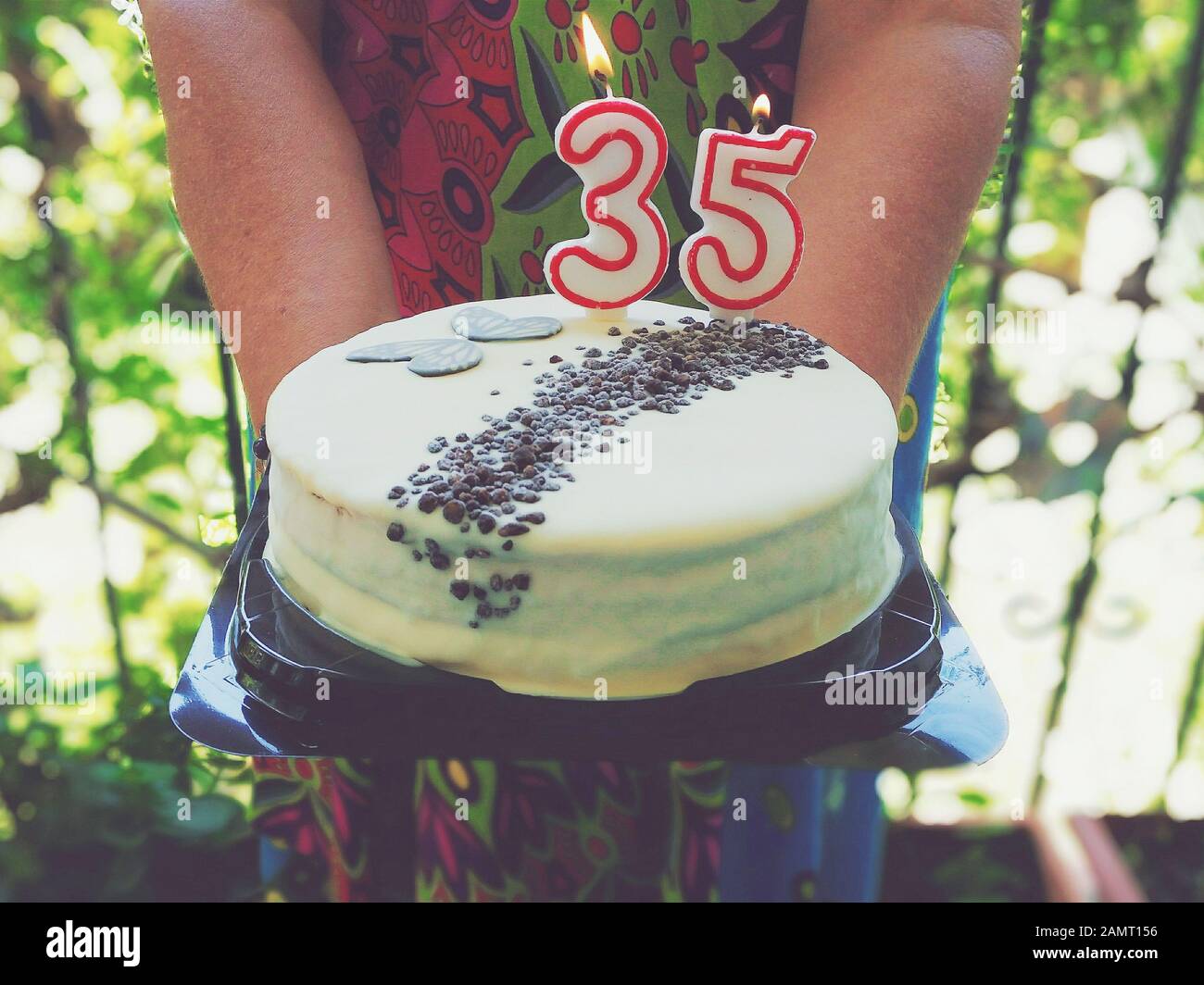 Donna che tiene una torta di compleanno 35th Foto Stock