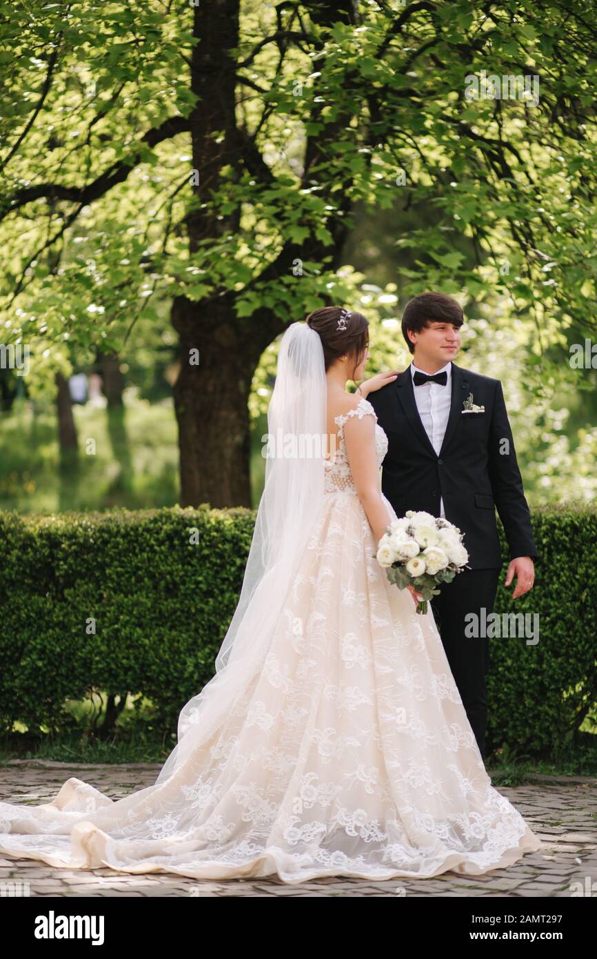 Felice lo sposo e la sposa a piedi nel parco. Donna affascinante con uomo bello trascorrere del tempo insieme Foto Stock