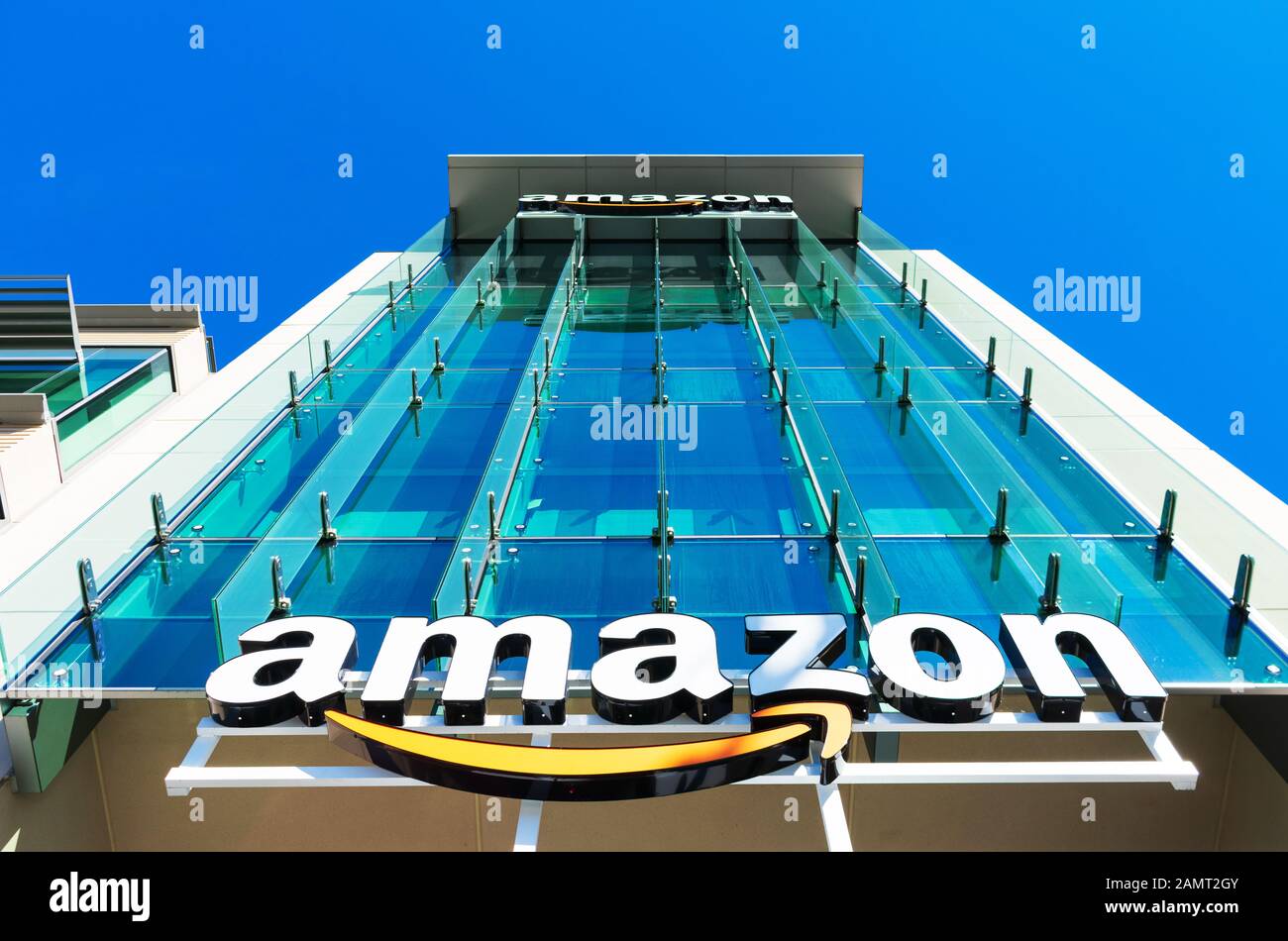 Logo Amazon con il suo caratteristico sorriso arancione sulla facciata in vetro del campus aziendale a Silicon Valley Foto Stock