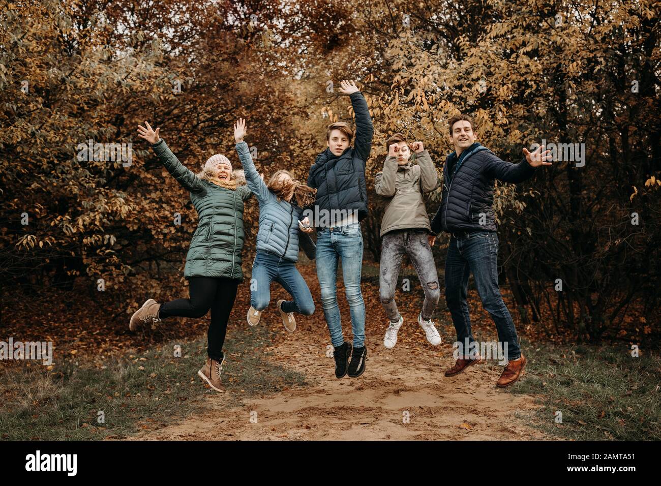 Ritratto di una famiglia che salta in aria nel paesaggio rurale, Paesi Bassi Foto Stock