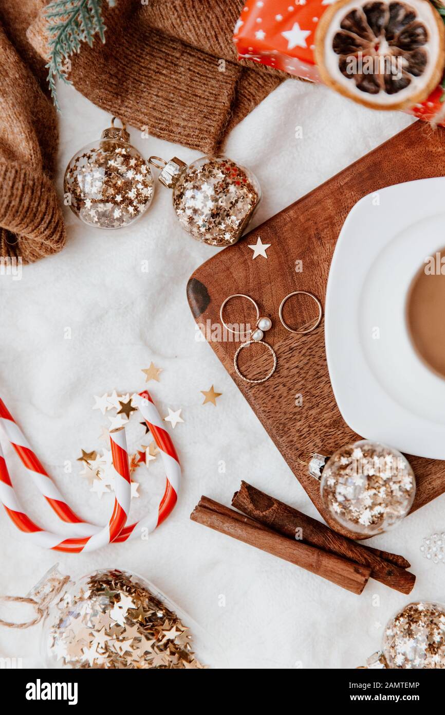 Una tazza di caffè accanto a baubles di Natale, gioielli e decorazioni natalizie Foto Stock