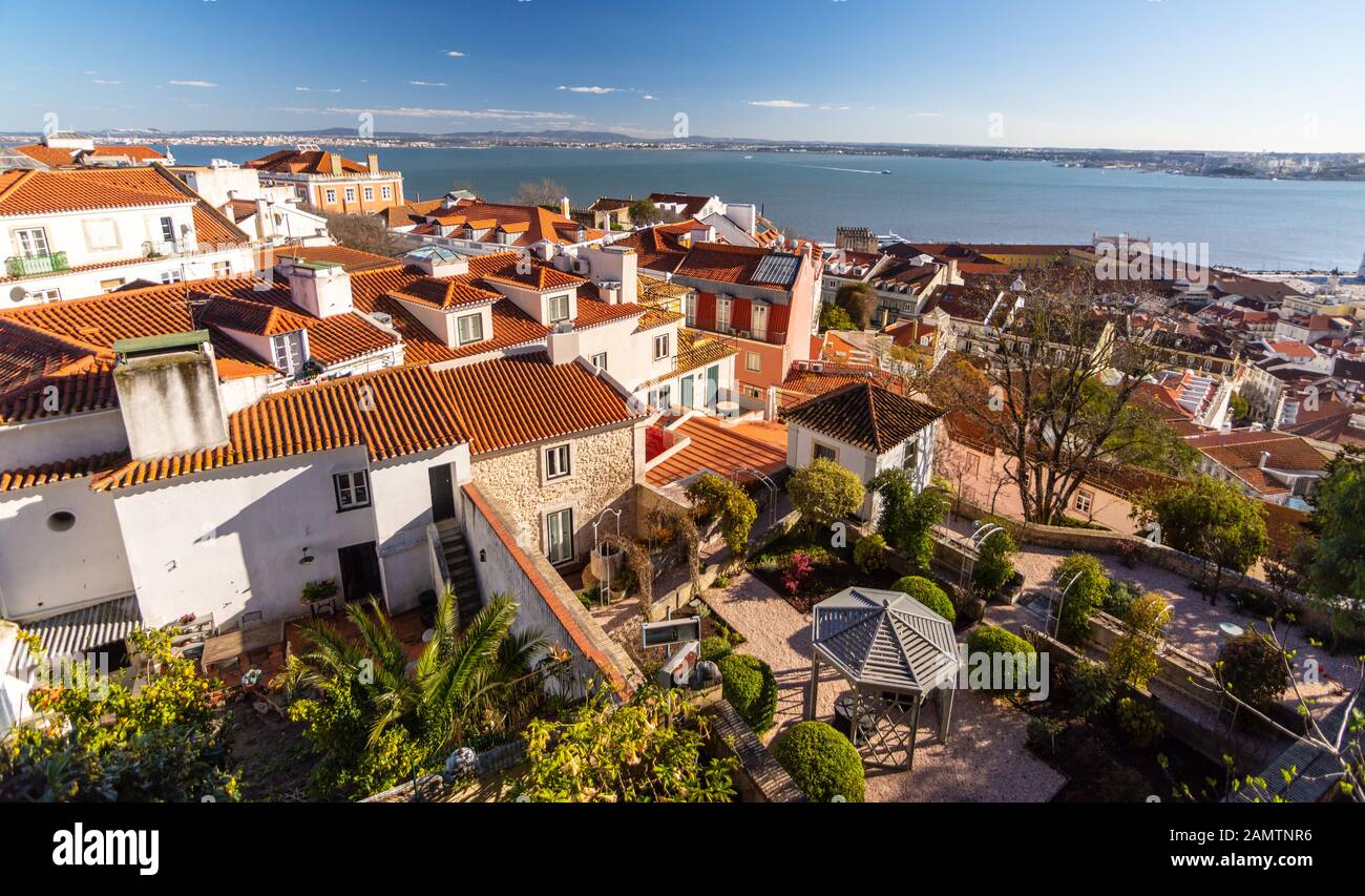 Lisbona, Portogallo - 11 marzo 2016: Case tradizionali, giardini e uffici si trovano su una collina che conduce all'estuario del fiume Tago a L. Foto Stock