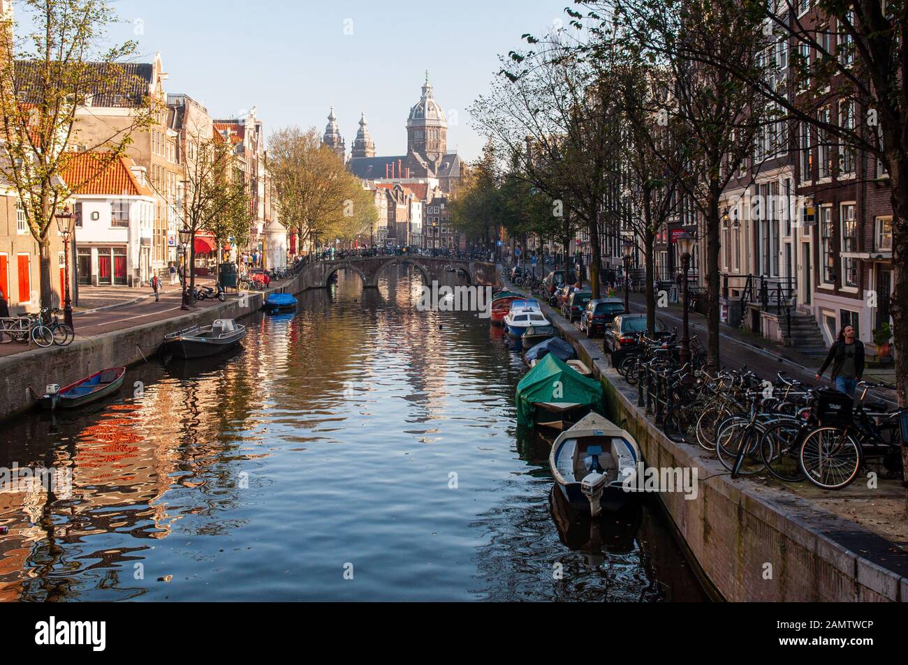 Amsterdam, Paesi Bassi - 2 ottobre 2011: Il sole del mattino splende sulla chiesa e sui canali Basiliek van de Heilige Nicolaas nel centro di Amsterdam. Foto Stock