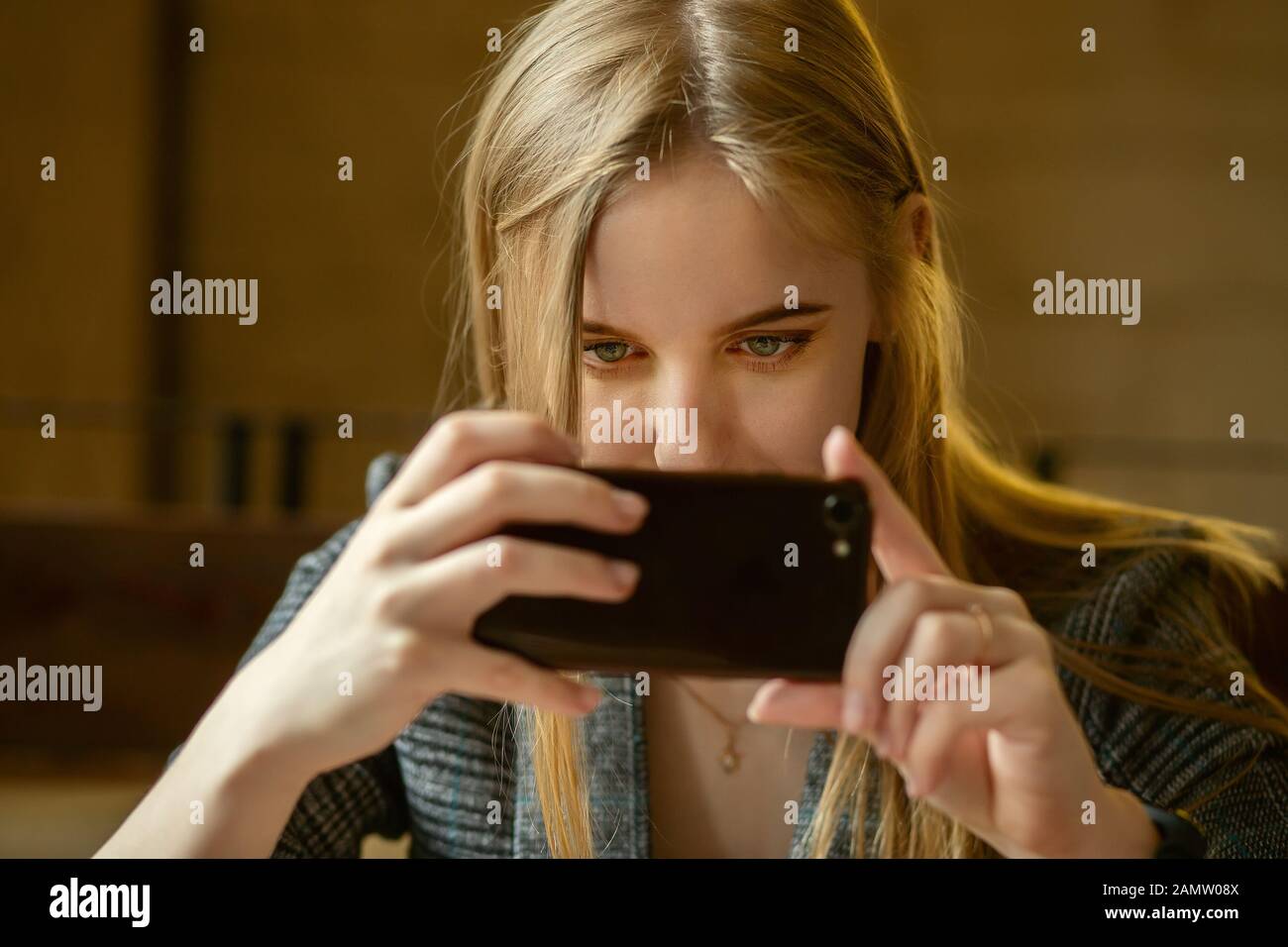 Giovane donna bionda con telefono cellulare facendo scattare Foto Stock