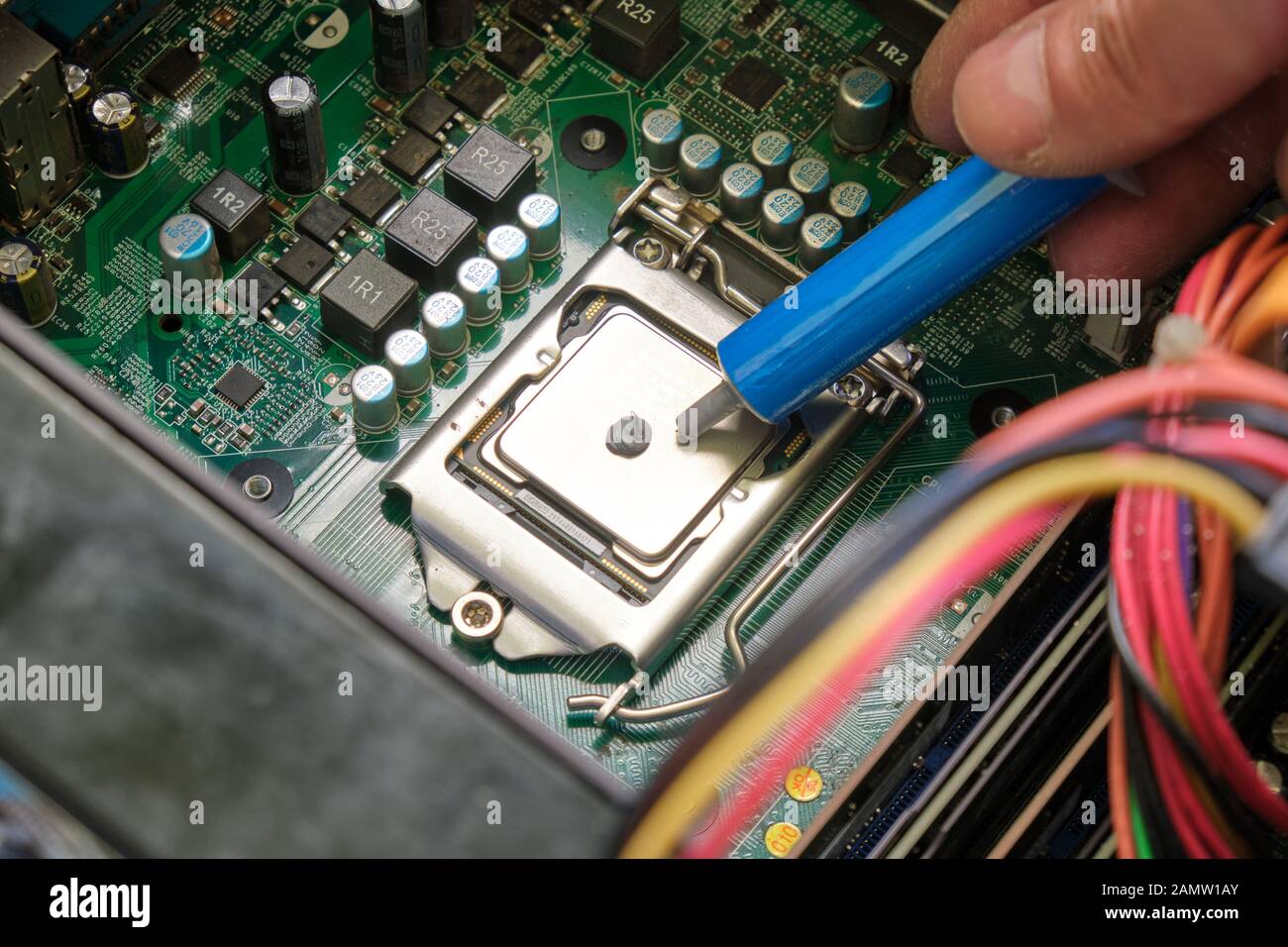 Applicazione di gel termico a una CPU del computer con alloggiamento nel socket della scheda madre. Foto Stock
