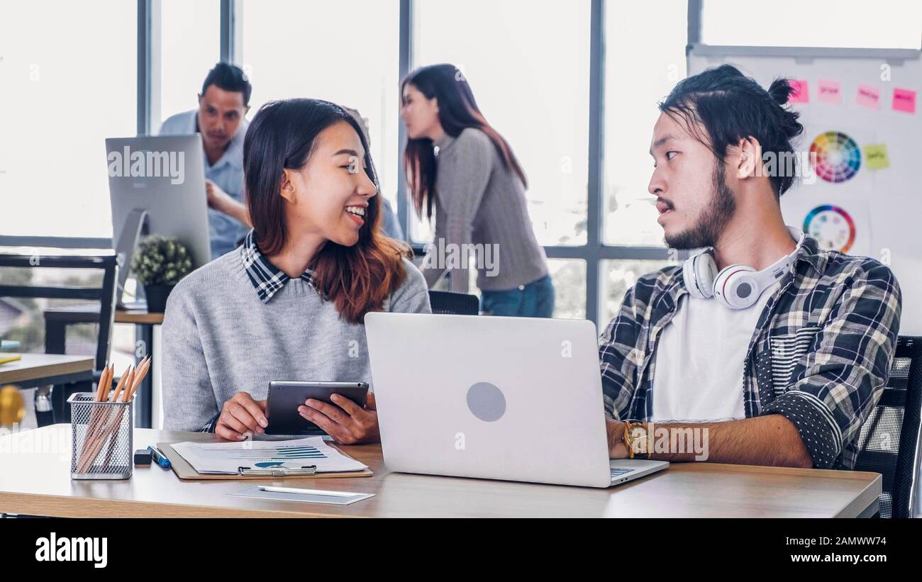 Due dei designer creativo riunione informale con il portatile in ufficio moderno in mattinata a scrivania.informale stile di vita sul posto di lavoro. Foto Stock