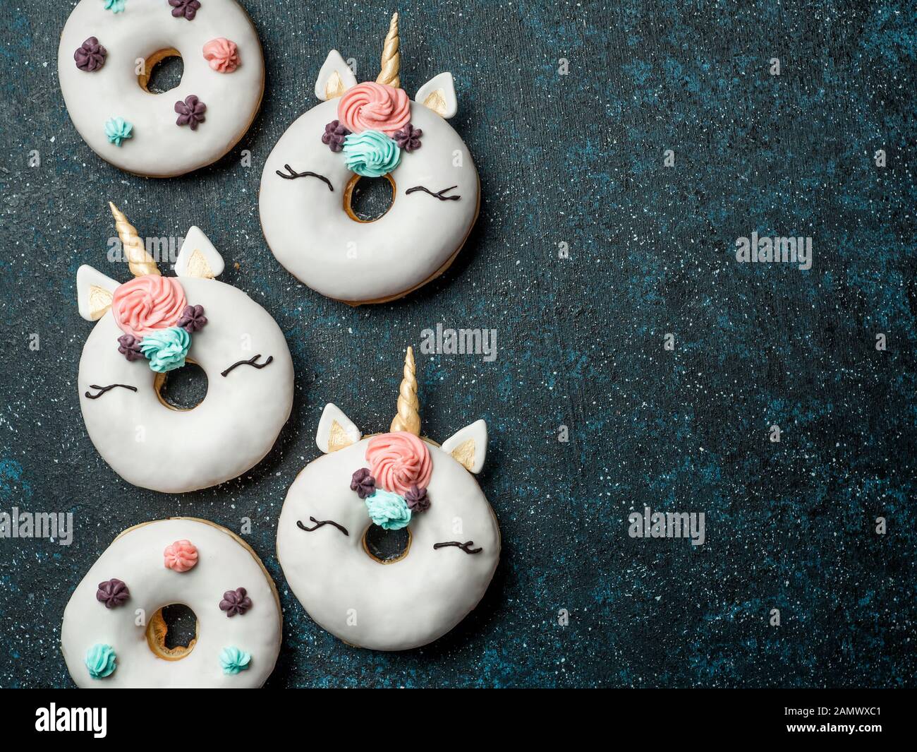 Unicorn ciambelle su sfondo scuro. Ciambella alla moda unicorn con smalto bianco. Vista superiore piatta o laici. Copia spazio per il testo. Foto Stock