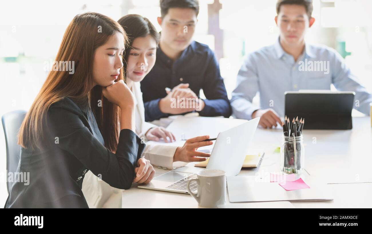 Vista ravvicinata di un gruppo di persone di affari il brainstorming sul loro progetto in semplice sala riunioni Foto Stock