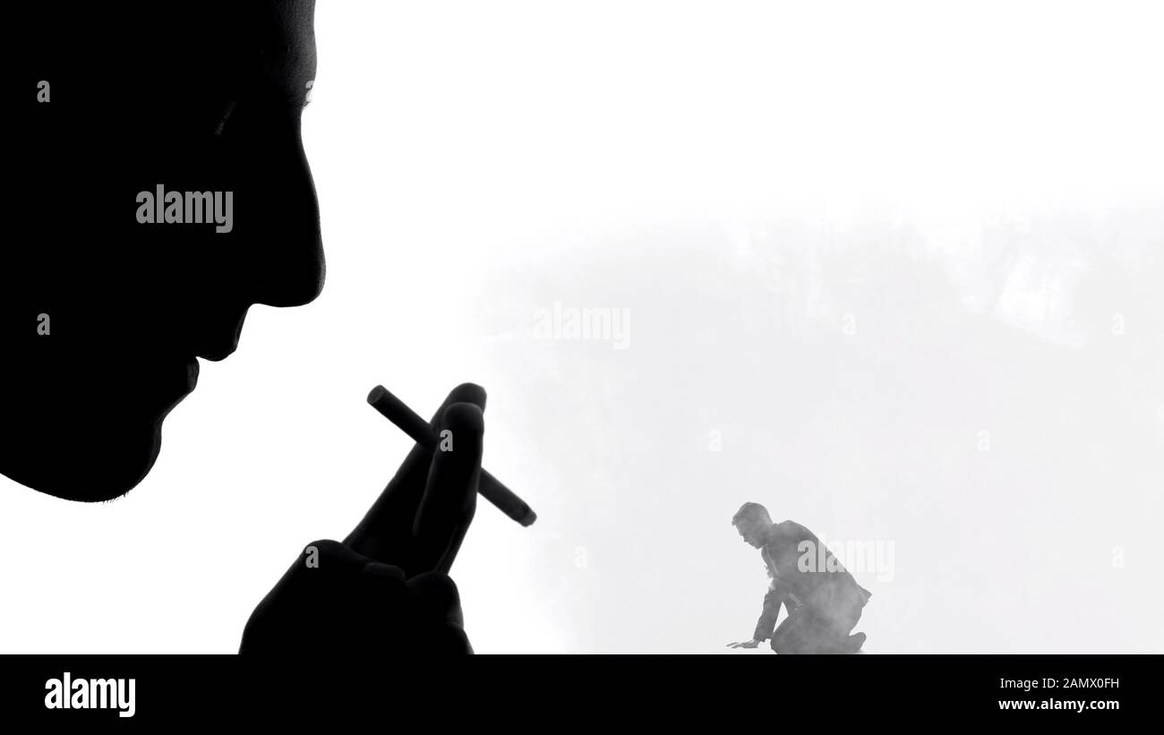 Silhouette di sigaretta maschio fumante, esalante fumo su uomo piccolo, abitudine dannosa Foto Stock