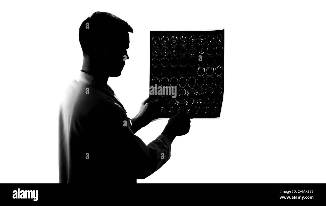 Silhouette di neurologo giovane che esamina i risultati di mri, malattia di cervello, occupazione Foto Stock