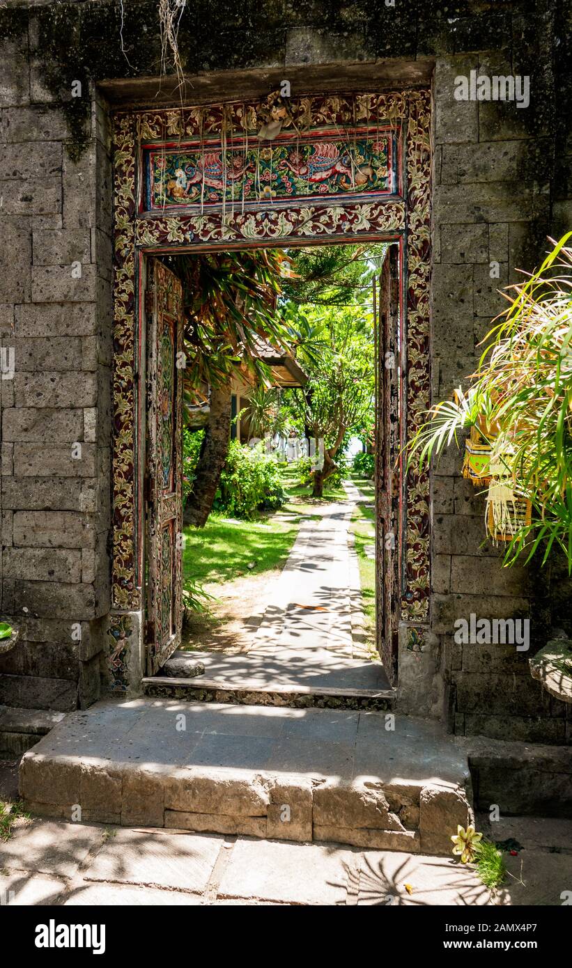 Porta decorata in legno dipinto all'ingresso di un giardino esotico. Foto Stock