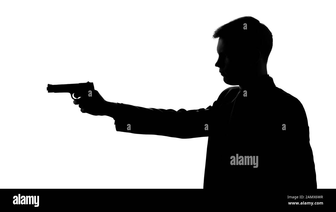Uomo in tuta pistola di puntamento, minacciosa con arma, vendetta, silhouette vista laterale Foto Stock