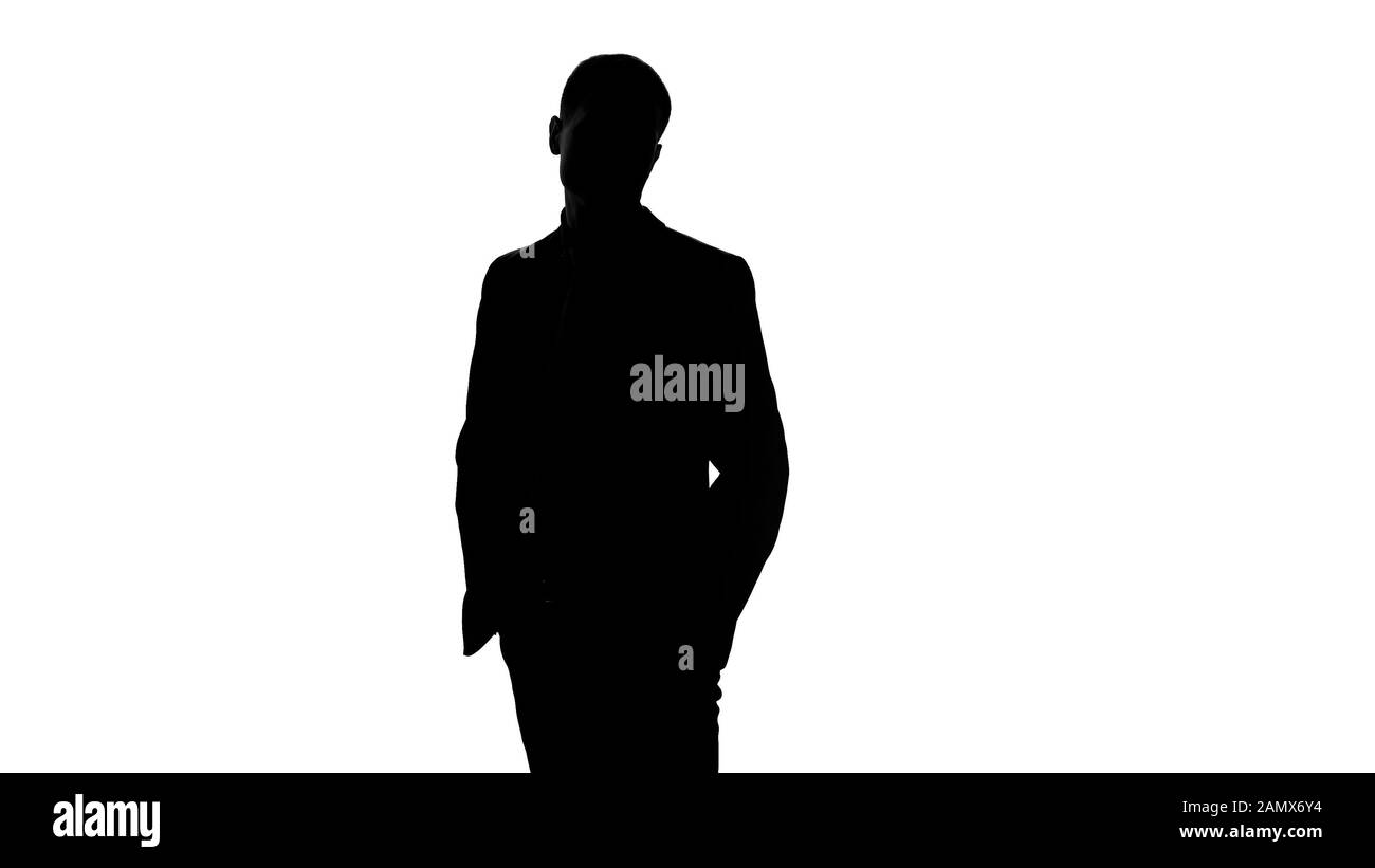 Elegante uomo d'affari in tuta in attesa di riunioni, mettere le mani in tasche, sicuro Foto Stock