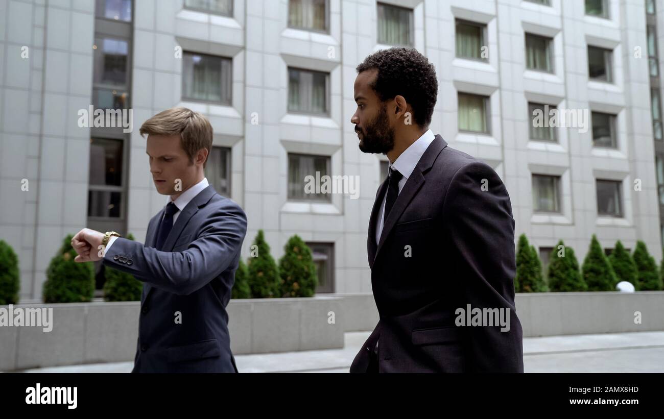 Uomini che vanno a importanti incontri di affari, guardando guardare, gestione del tempo Foto Stock