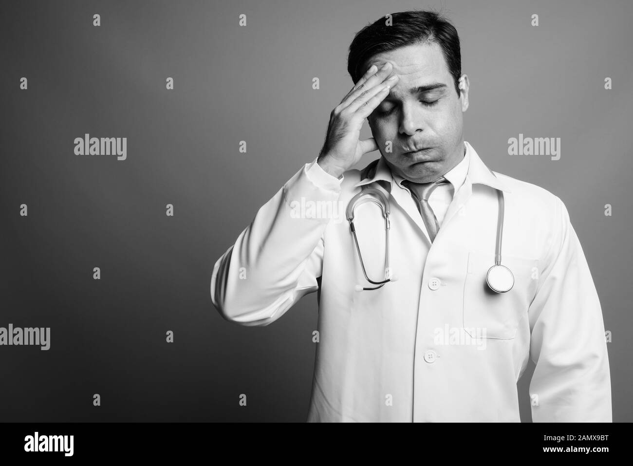 Bello il persiano uomo medico contro uno sfondo grigio Foto Stock