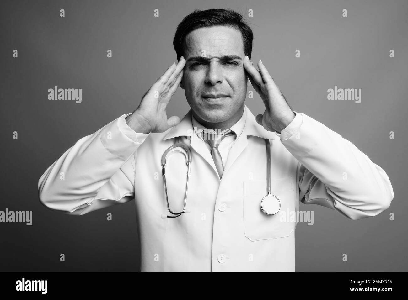 Bello il persiano uomo medico contro uno sfondo grigio Foto Stock