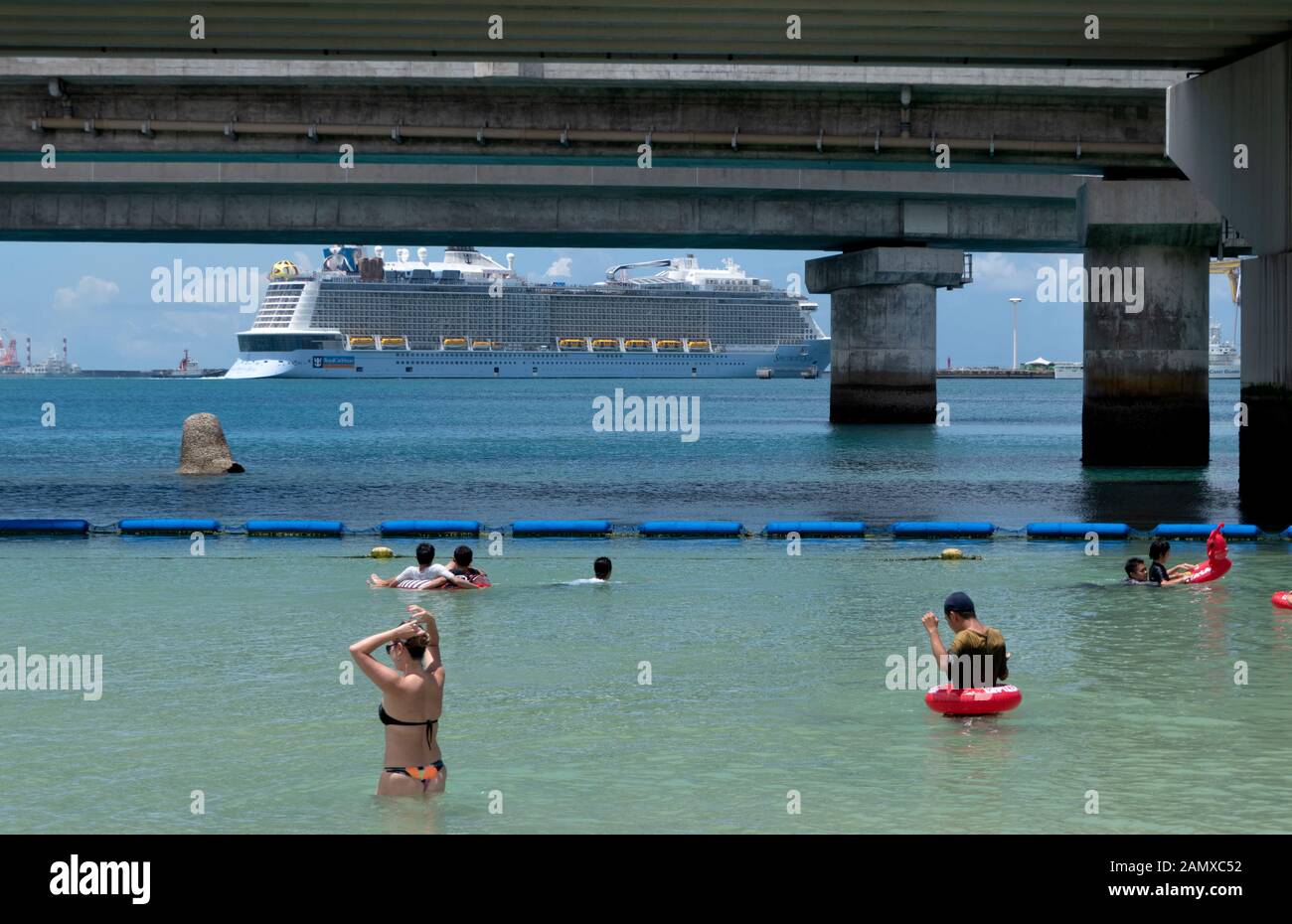 Naminoue Beach a Naha, Okinawa, in Giappone, Asia. Il popolo giapponese di nuoto, turisti rilassante durante le vacanze. Il mare cristallino di acqua con la nave di crociera Foto Stock