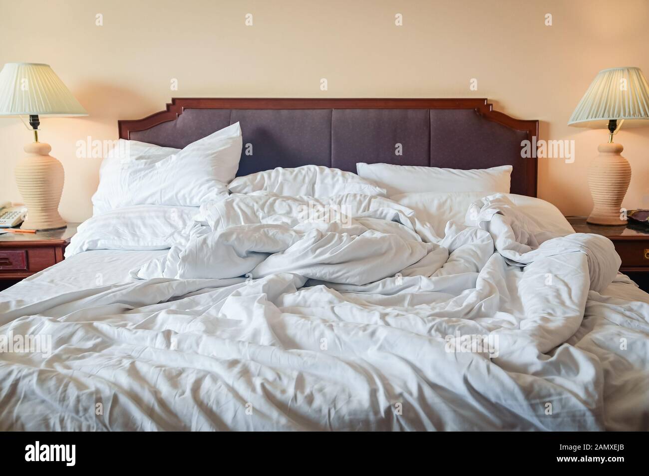 Letto disfatto accartocciata con lenzuola, coperte e cuscini dopo la comodità di piumone dormire svegliarsi al mattino Foto Stock
