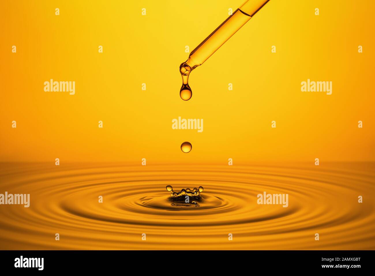 Ondulazione della superficie d'oro di liquido di colore giallo con gocce. Foto Stock