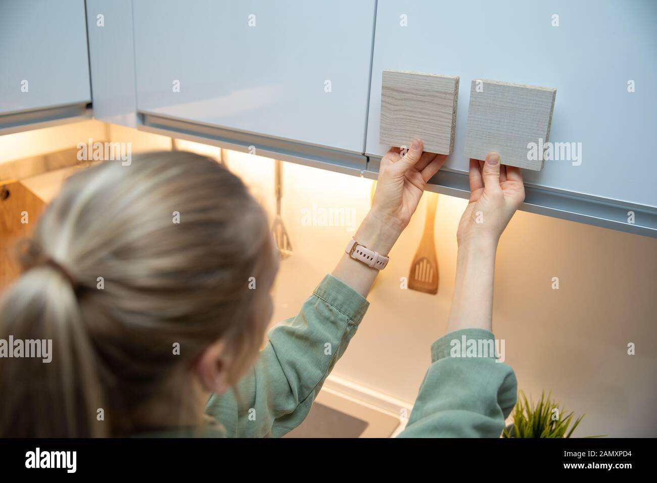 donna che sceglie i materiali del mobile della cucina dai campioni laminati Foto Stock