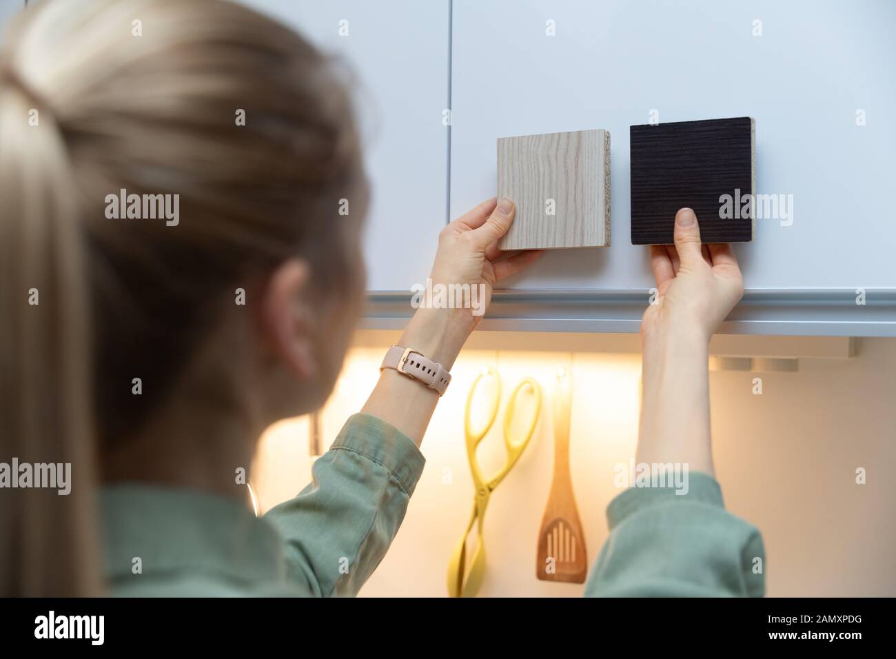 donna che sceglie i materiali del mobile della cucina dai campioni laminati Foto Stock