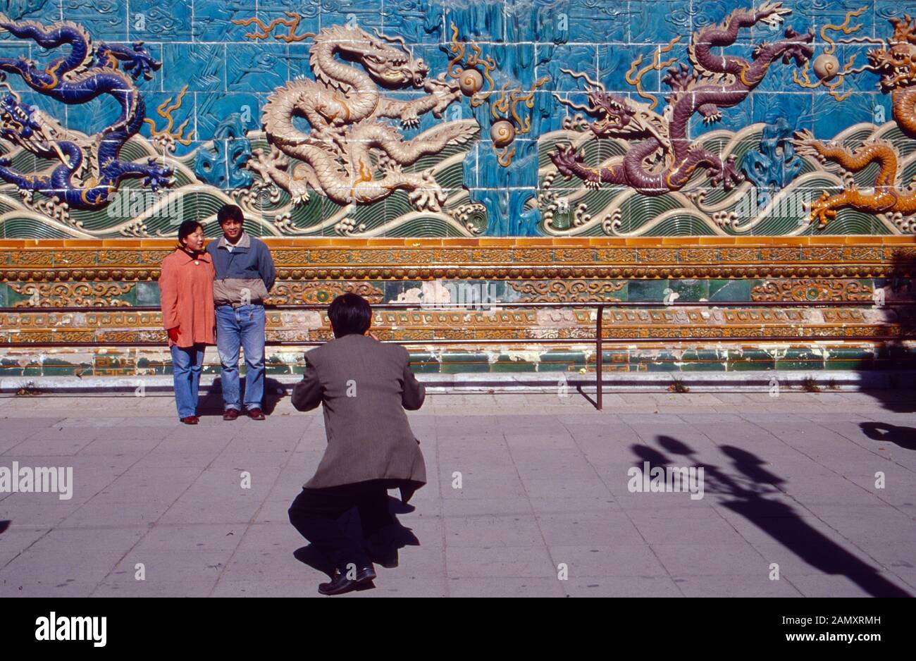 Ein Schnappschuß für das Familienalbum vor historischer Kulisse a Pechino, Cina um 1990. Un'istantanea per l'album fotografico di famiglia di fronte a un drago storico fissato a Pechino, Cina intorno al 1990. Foto Stock