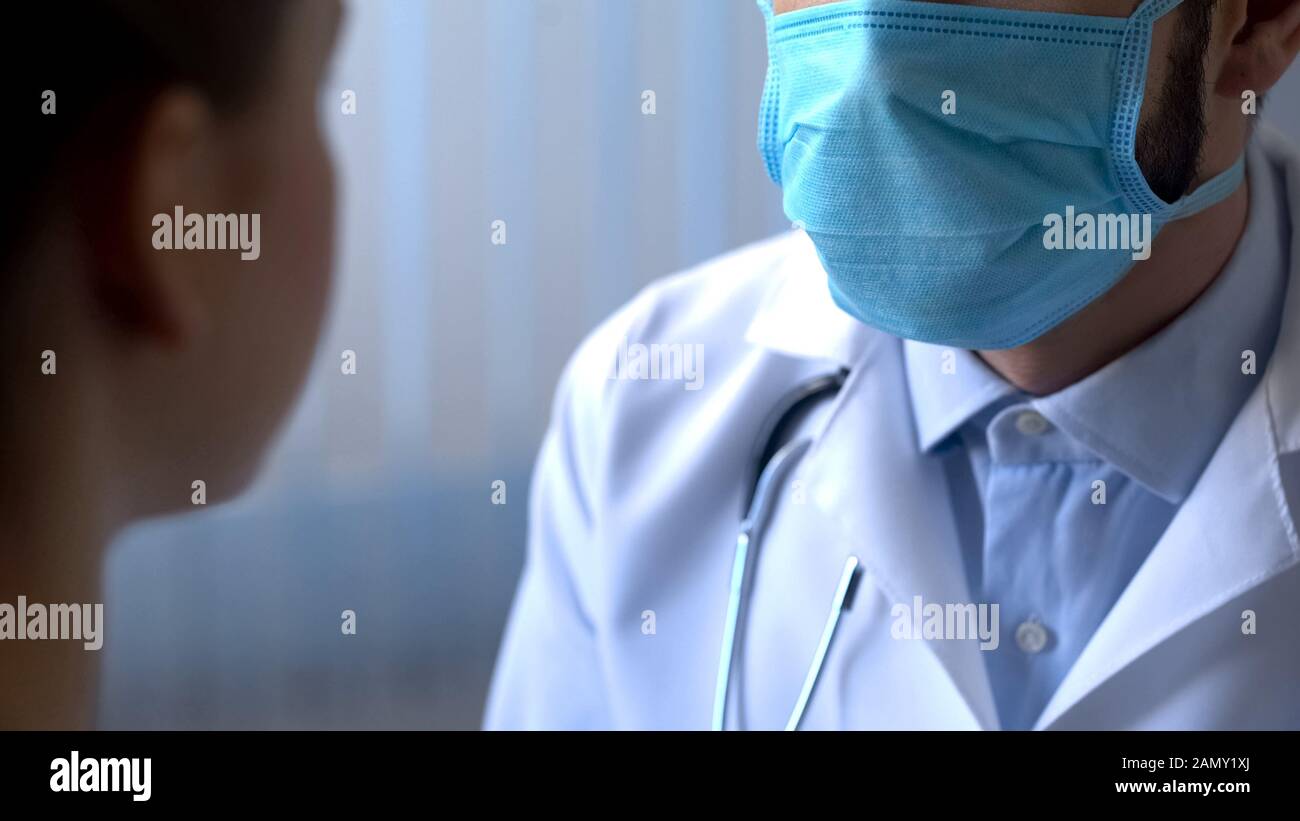 Medico in maschera di medicina esame del paziente, diagnostica in clinica, epidemia Foto Stock
