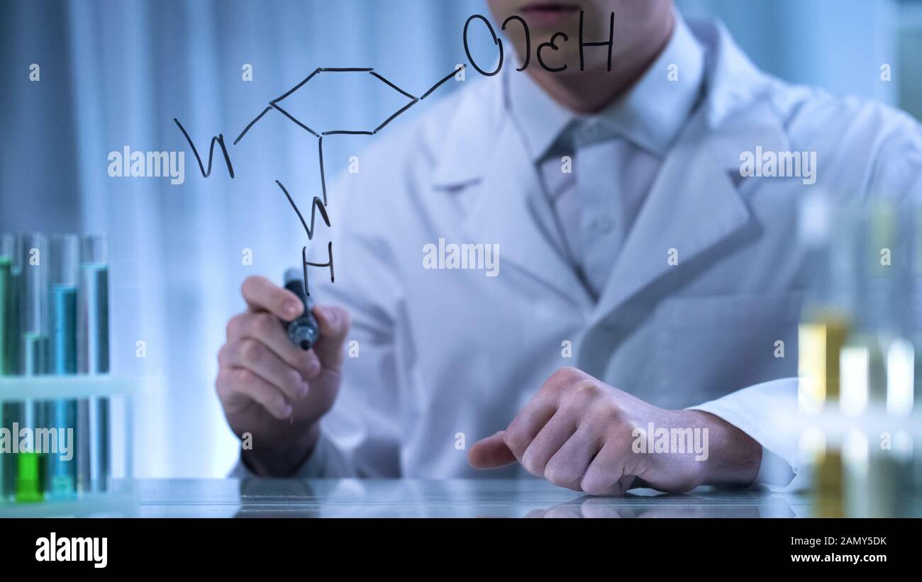Farmacista scrivere formula chimica strutturale su tavola trasparente, ricerca Foto Stock