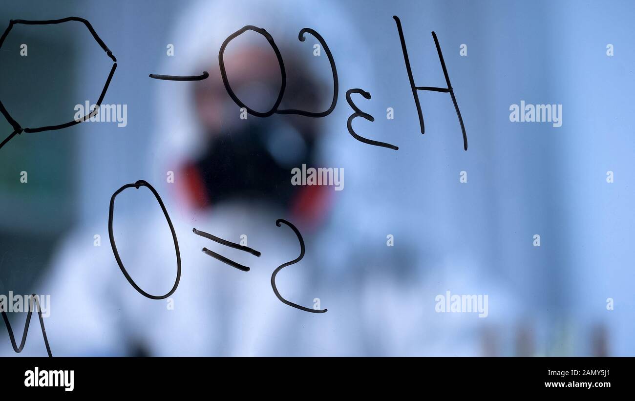 Scrittura di formule chimiche strutturali su tavole trasparenti, ricerche chimiche Foto Stock
