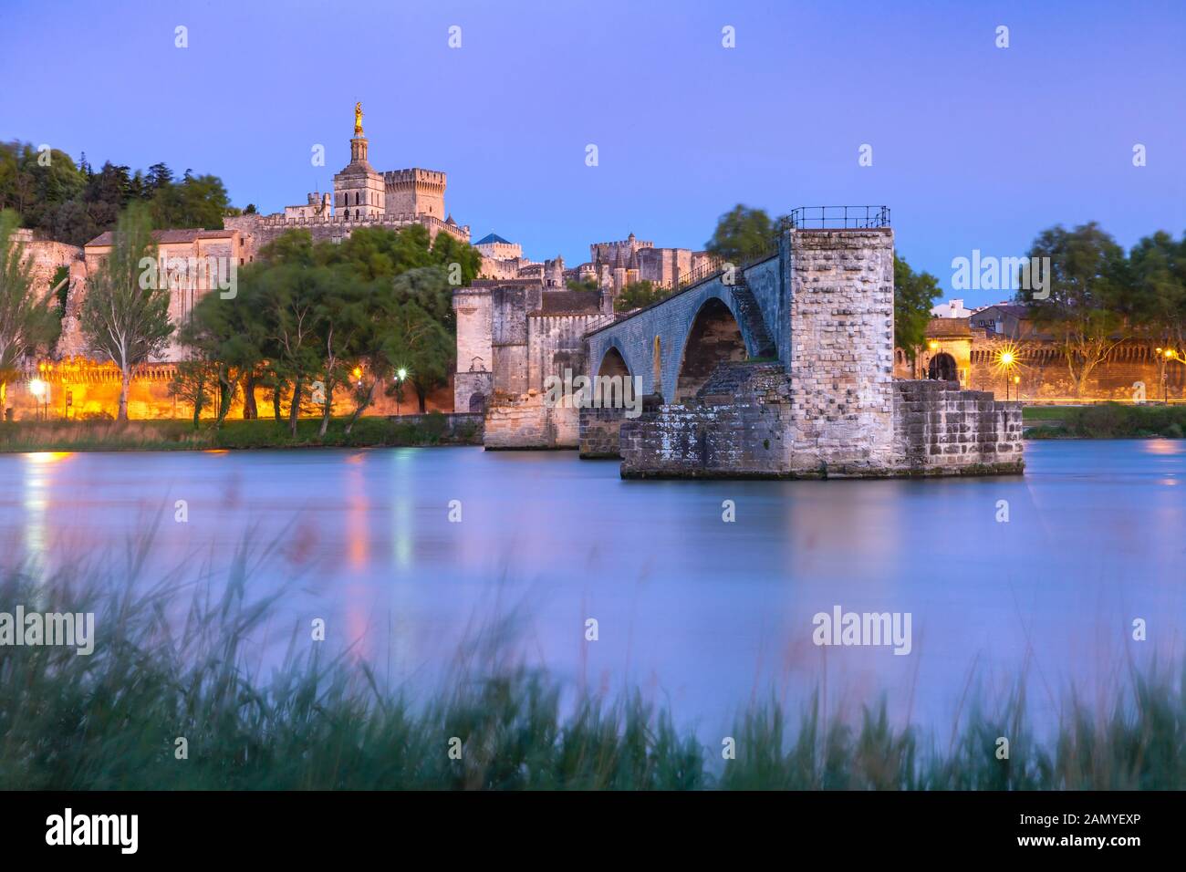 Vista panoramica del celebre Medieval Saint Benezet bridge e il Palazzo dei Papi durante la sera ore blu, Avignon, Francia meridionale Foto Stock