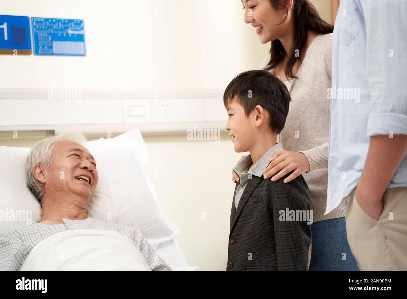madre asiatica padre e figlio che visitano nonno in ospedale Foto Stock