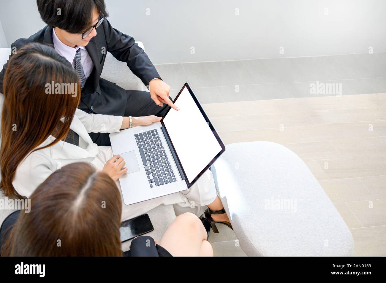 Gli uomini d'affari stanno giocando ai telefoni cellulari e utilizzando i computer Foto Stock