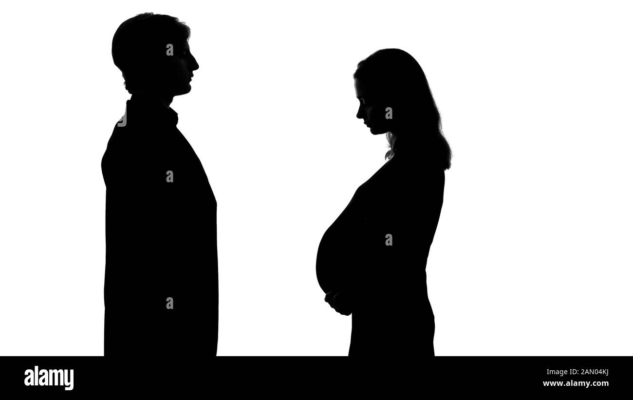 Donna incinta che rimane di fronte al padre futuro, riconoscere il bambino, silhouette Foto Stock