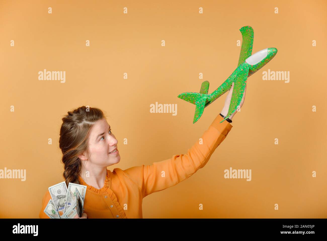 Ragazza con aereo e denaro nelle sue mani, concetto di viaggi e vacanze. Foto Stock