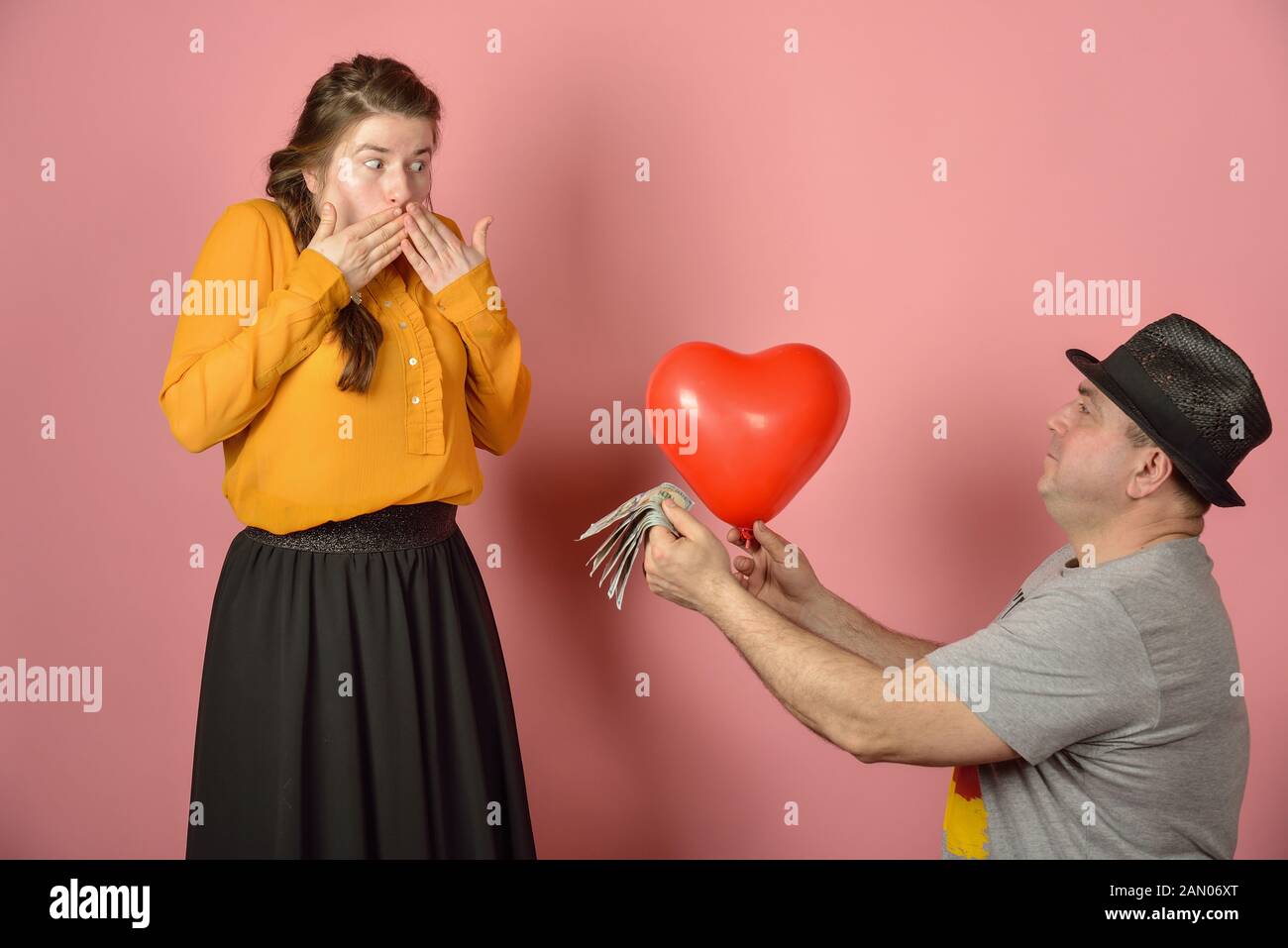 Un uomo dà un palloncino a forma di cuore del suo amato, congratulazioni tra gli appassionati. Foto Stock