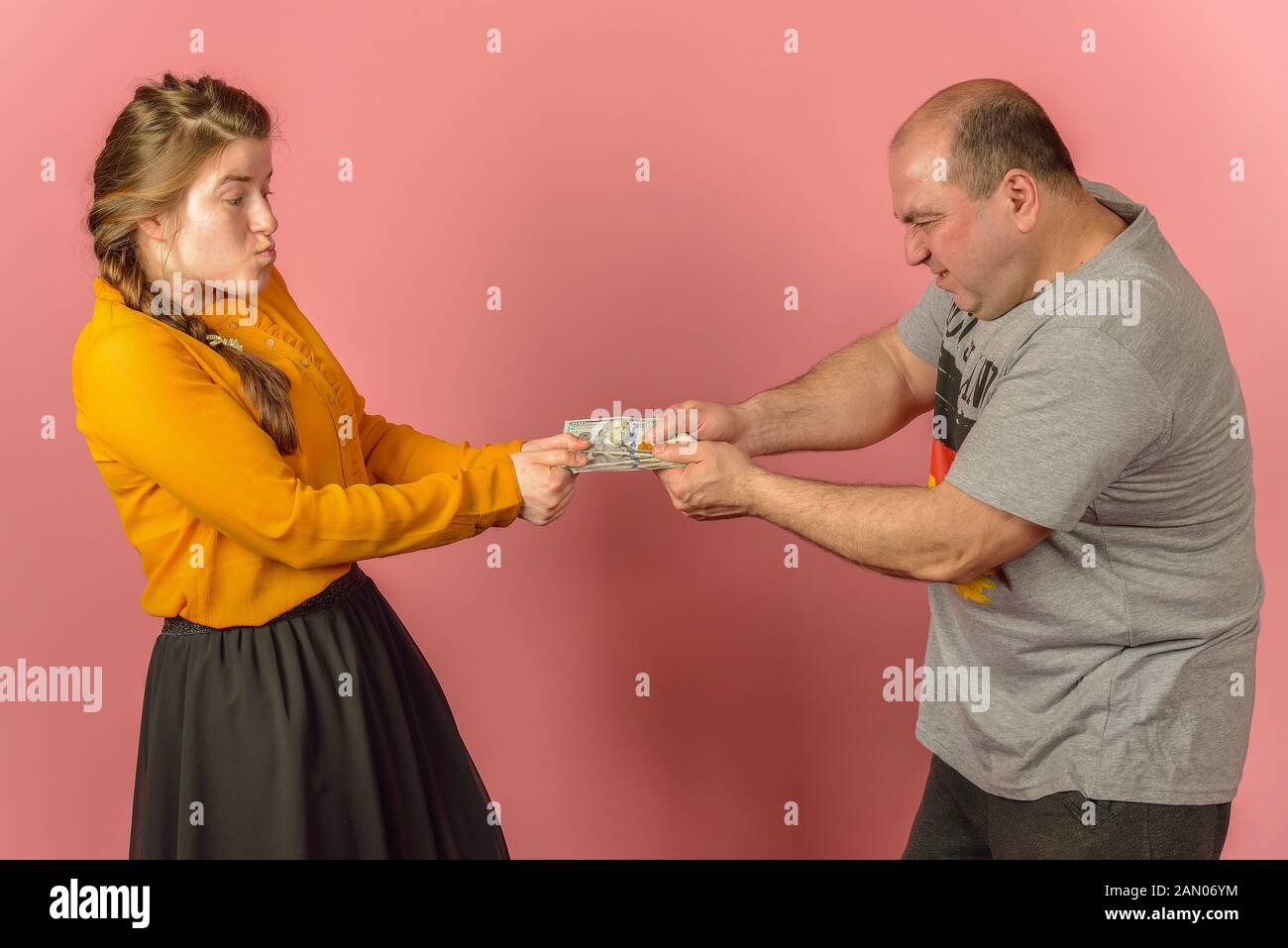 Una moglie prende il denaro da suo marito e vuole ricevere un regalo. L'avidità nella sfera sociale. La mancanza di fondi per i conflitti familiari. Foto Stock