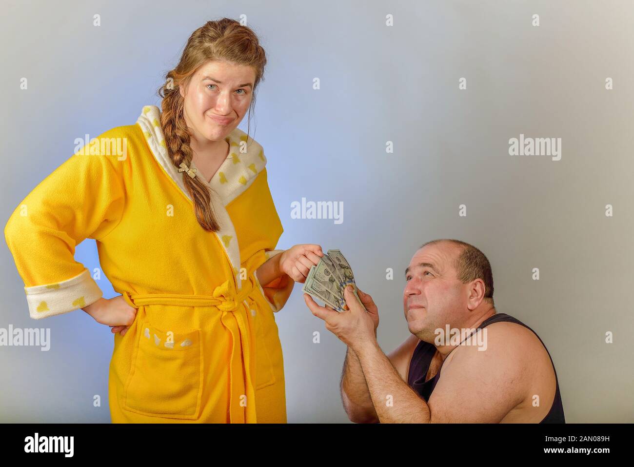 Il marito è paura di sua moglie e di evitare un litigio dà i suoi ultimi soldi, il concetto di problemi sociali nelle famiglie. Foto Stock