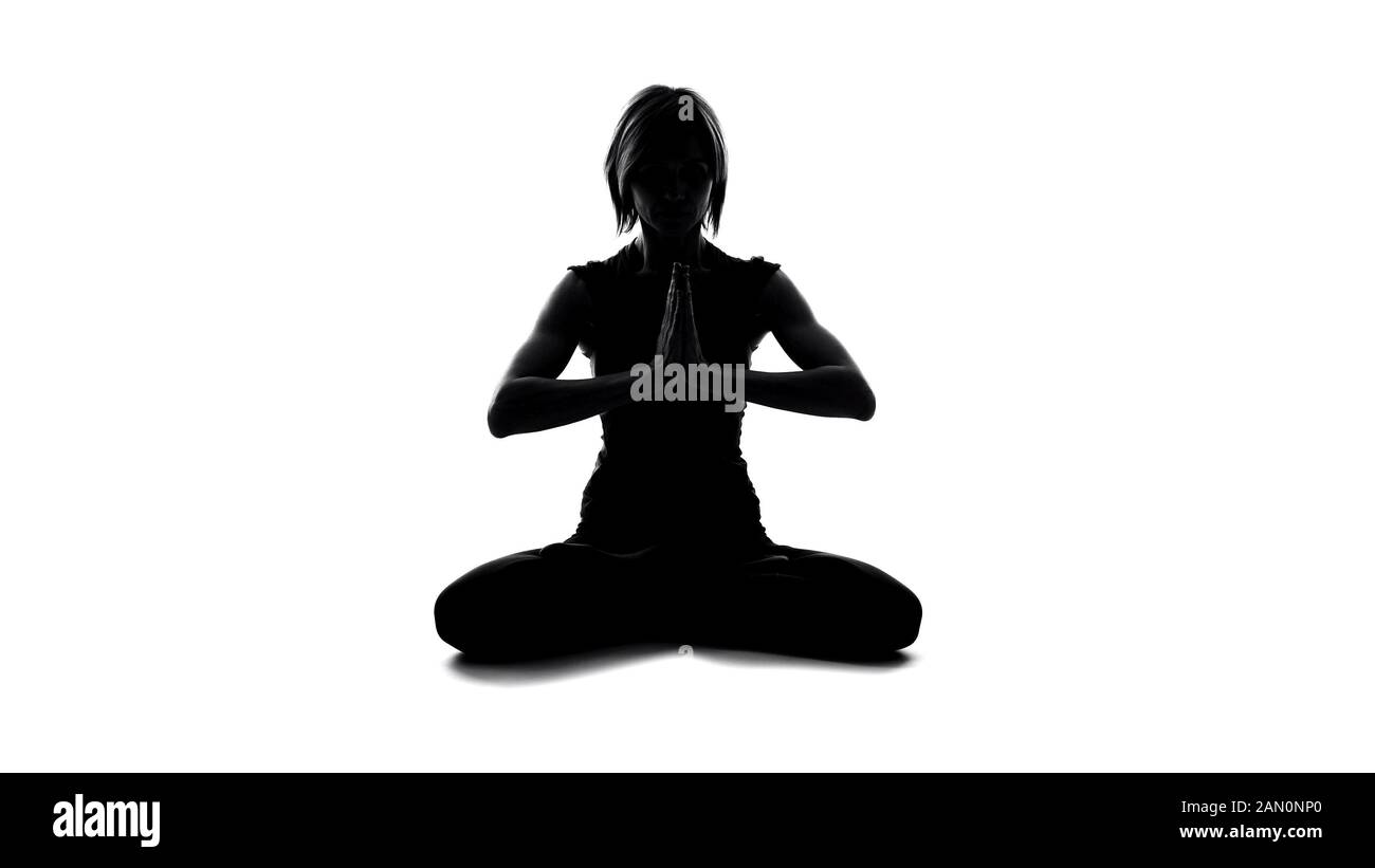 Donna sportiva che fa un gesto di namaste e medita in posa di loto, equilibrio yoga Foto Stock