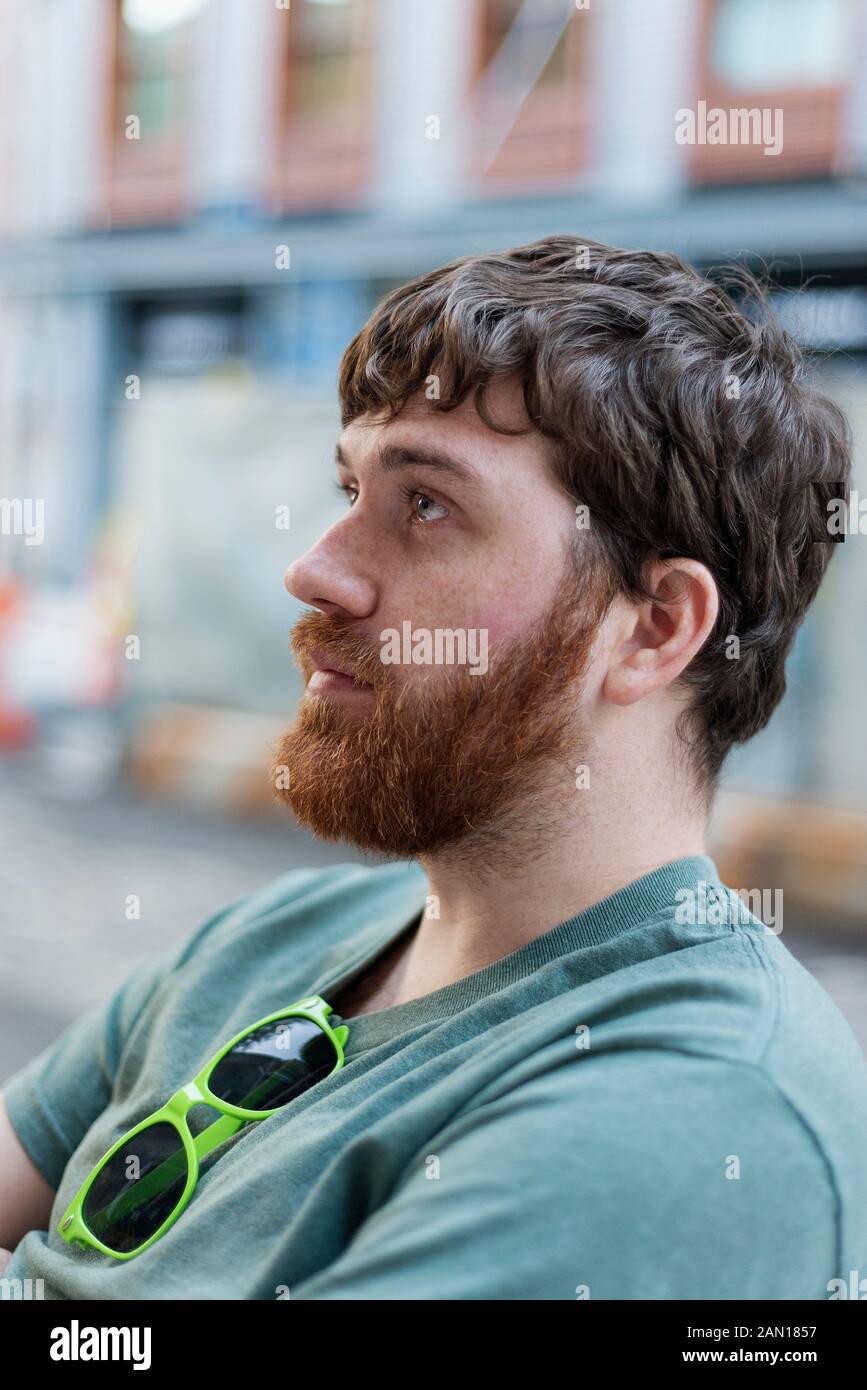 Un uomo (20 anni) seduto all'aperto a Lower Manhattan. Foto Stock