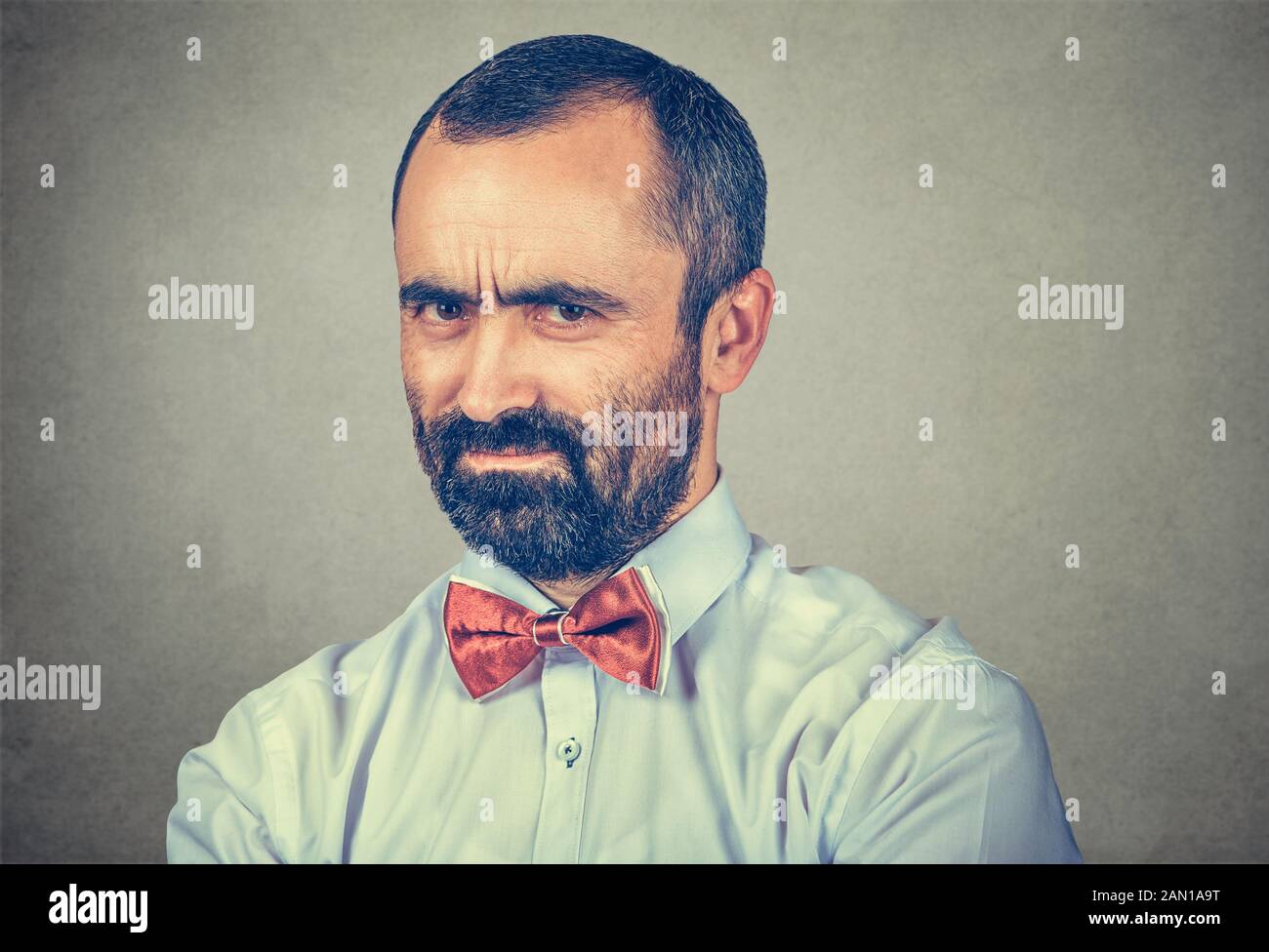 Closeup ritratto di arrabbiato ragazzo grumpy che guarda molto dispiaciuto isolato su sfondo grigio parete. Emozioni umane negative espressione facciale sensazione Foto Stock