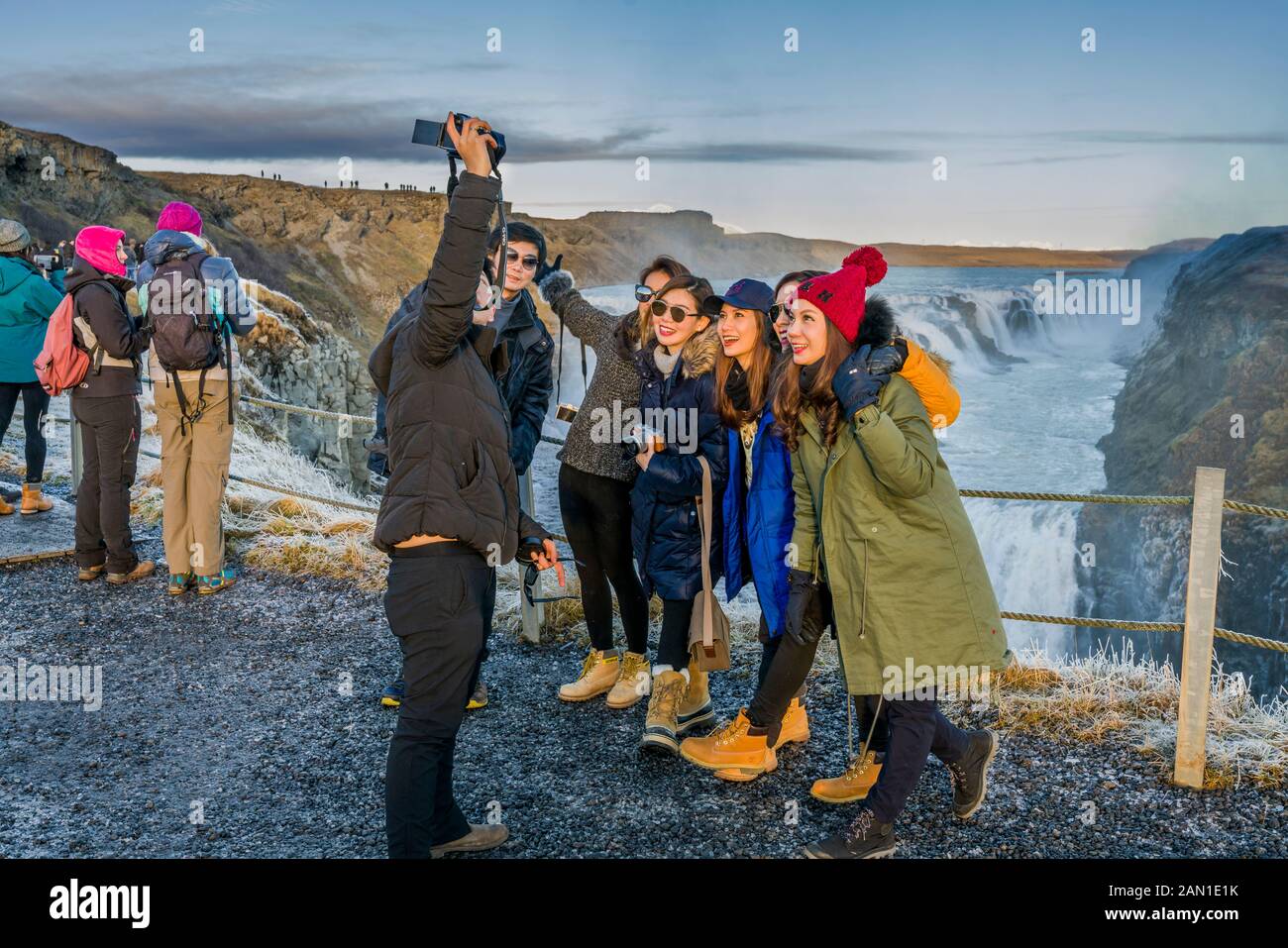 Turisti provenienti dall'Asia che scattano foto alle cascate di Gullfoss, Islanda Foto Stock