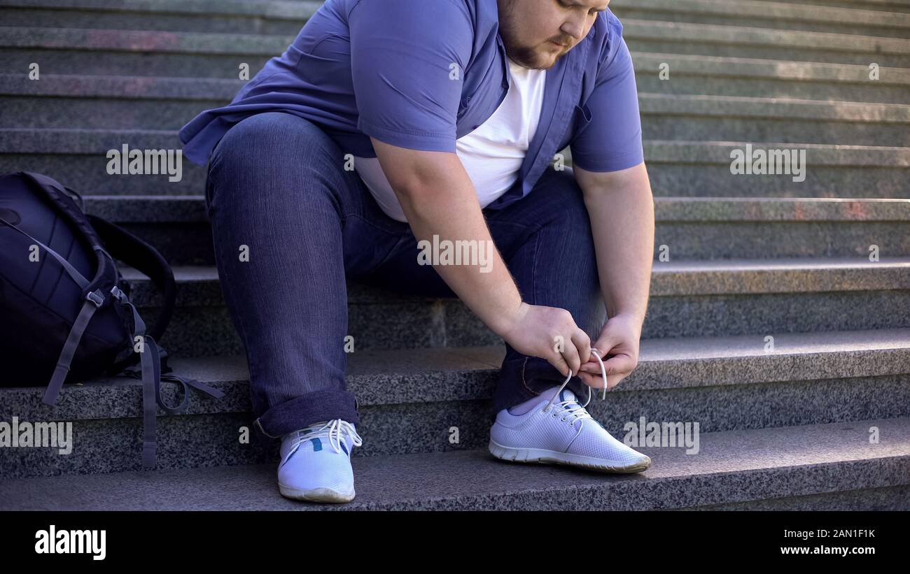 Duro per il giovane grasso di legare le scialaces, le sfide la gente obesa deve affrontare ogni giorno Foto Stock